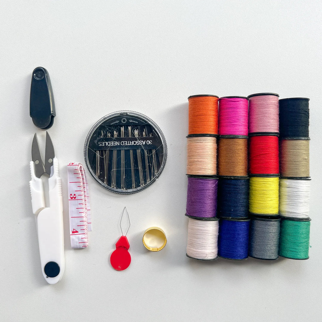 A top view of a basic sewing tool set including colorful thread, sharp needles, and scissors for quick home repairs.