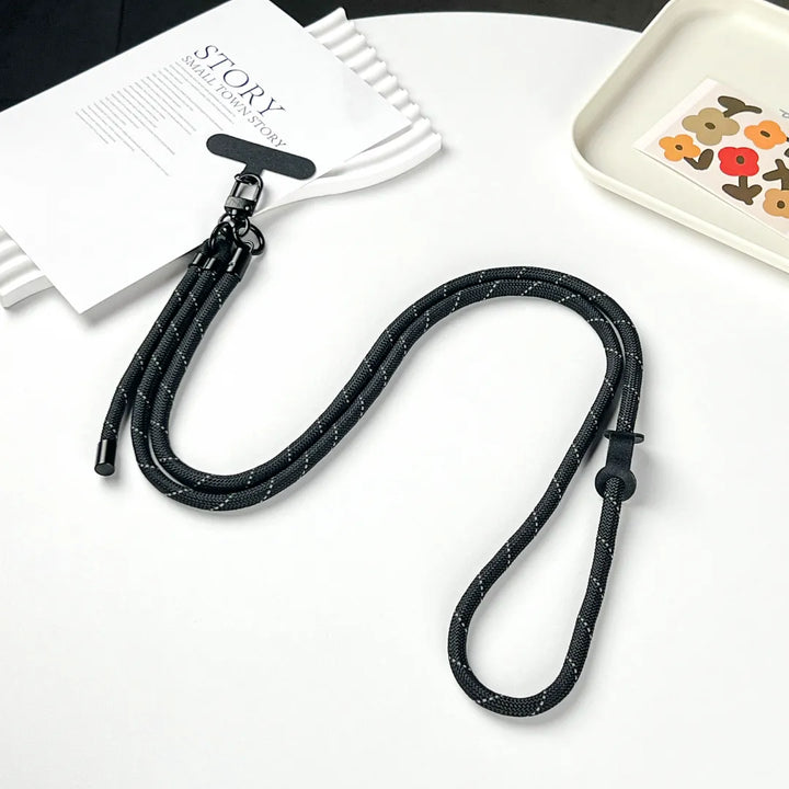 Adjustable length black phone strap shown clearly, suitable for different wearing preferences and body types#color_black