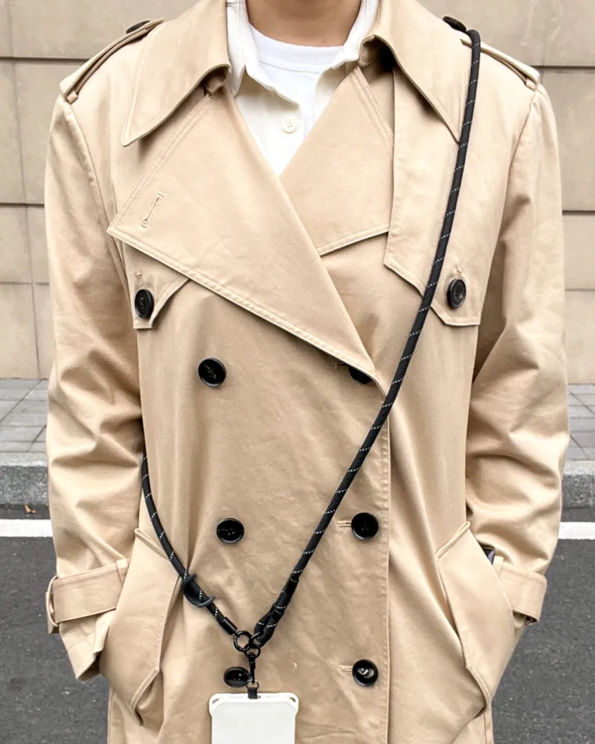Black phone strap styled with trench coat outfit, presenting a clean unisex look suitable for daily commuting#color_black