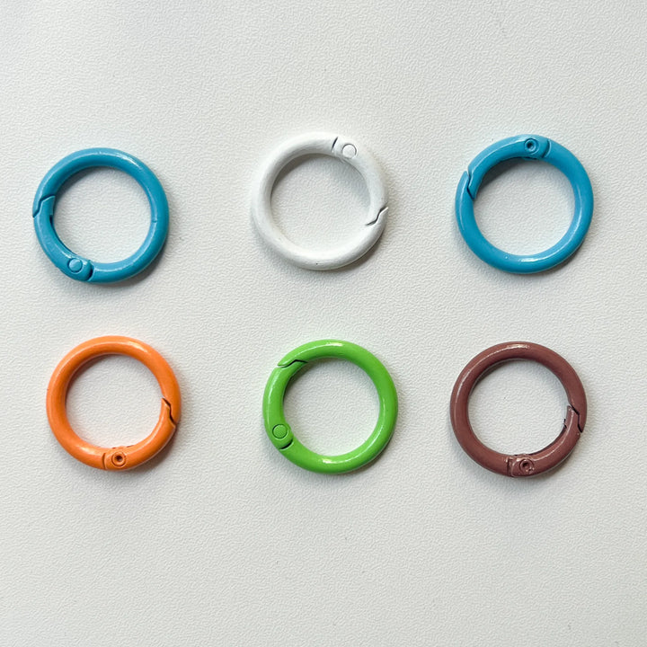 Assorted colorful round jump rings made of rust-proof metal, essential jewelry findings for connecting charms and clasps.