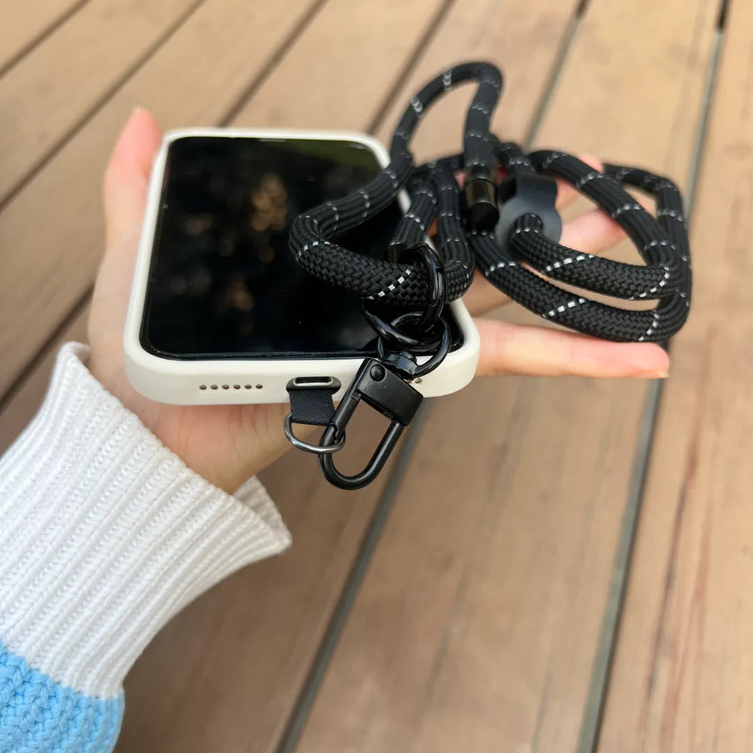 Black crossbody phone strap shown in hands free daily use, keeping the phone secure while moving comfortably#color_black