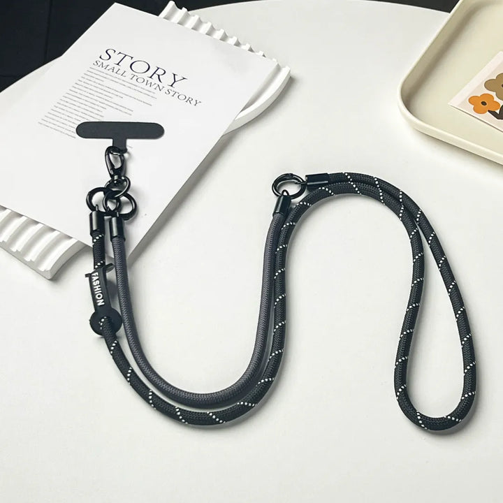 Detailed shot of the detachable gold-tone hooks on a premium black braided phone strapl#color_black