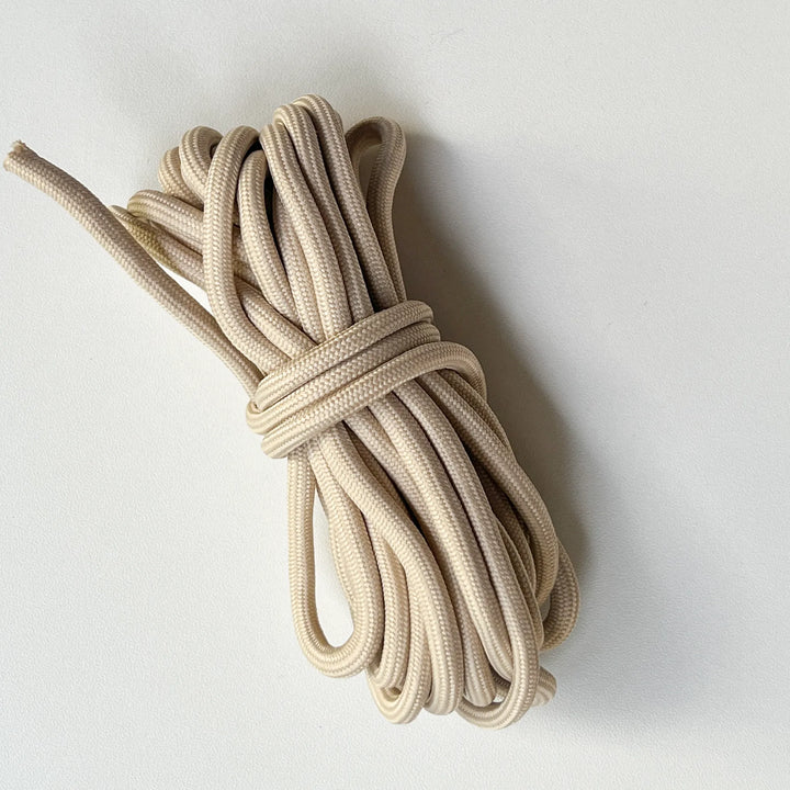 High-quality khaki braided paracord, heavy-duty utility string for outdoor tents and survival bracelet making.