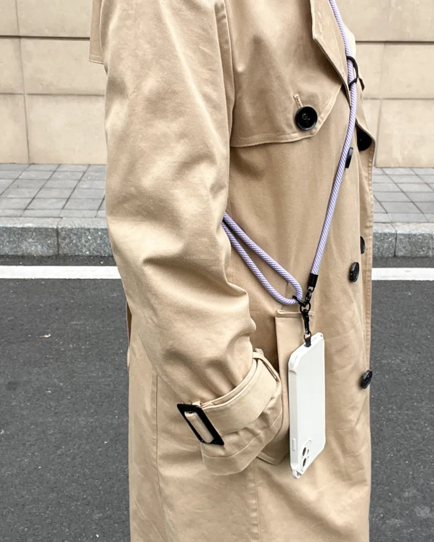 Lavender phone strap styled with trench coat outfit, blending cool tone color with hands free phone carrying#color_purple