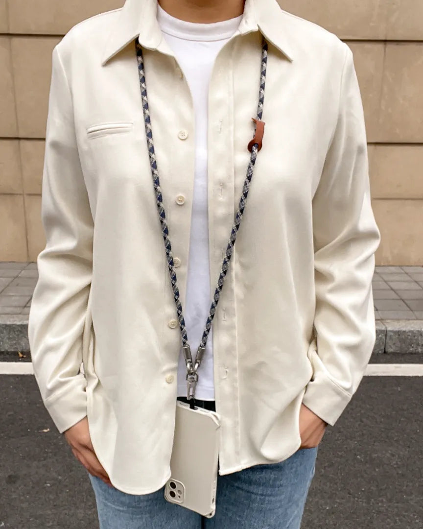 Elegant long patterned phone lanyard worn as a crossbody fashion accessory outdoors#color_blue