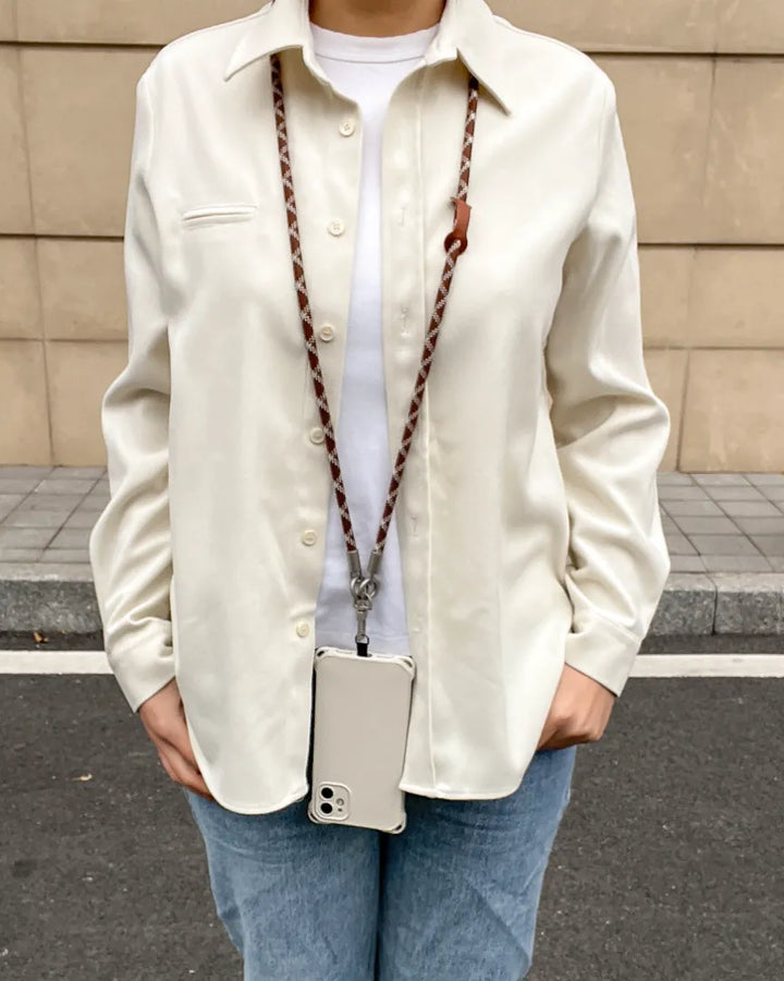 Long brown and white phone lanyard worn crossbody for a fashionable hands-free lifestyle#color_brown