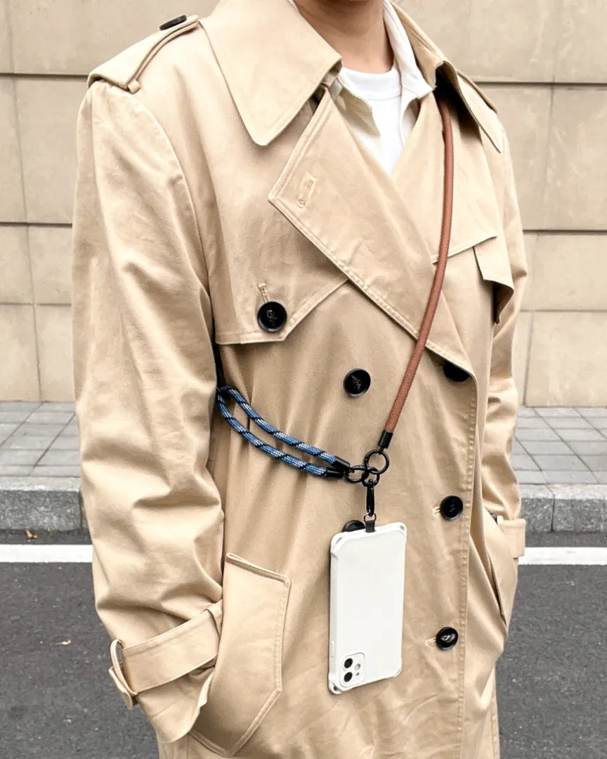 Outdoor lifestyle shot featuring a navy blue phone strap for a hands-free experience#color_brown