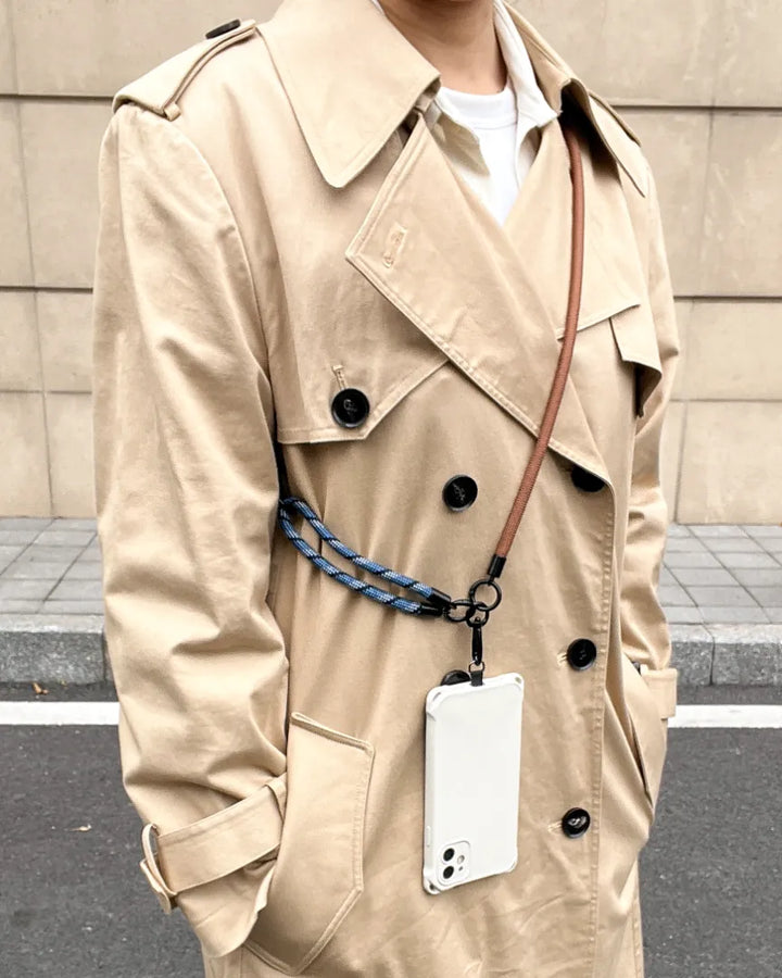 Outdoor lifestyle shot featuring a navy blue phone strap for a hands-free experience#color_brown