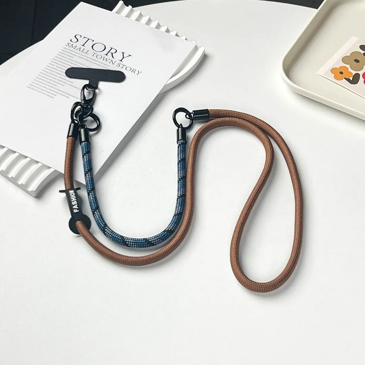 Detailed view of the premium gold clasp on a navy blue braided leather phone strap#color_brown