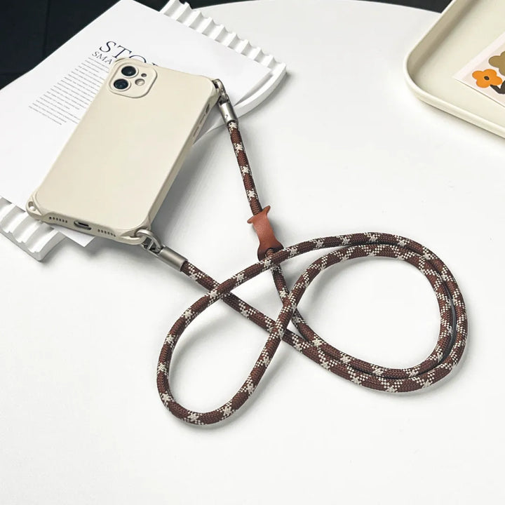 Elegant patterned phone lanyard wristlet in brown and white for a chic handheld look#color_brown