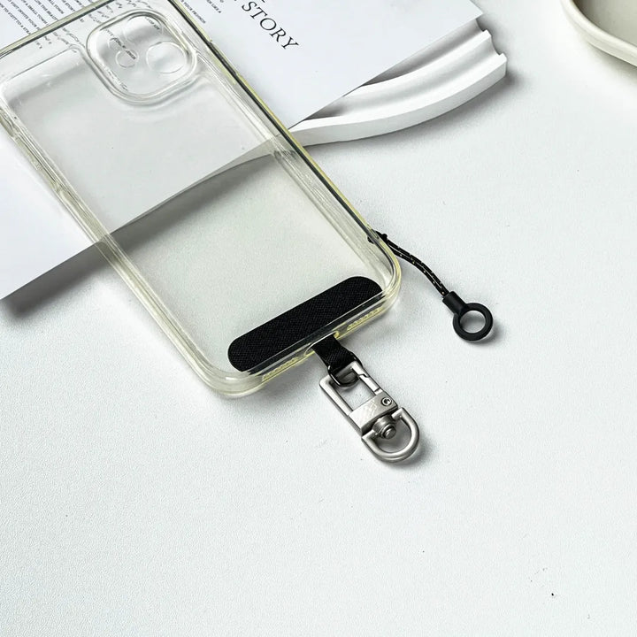 Detailed view of a phone lanyard tether pad being installed into a clear smartphone case#color_brown