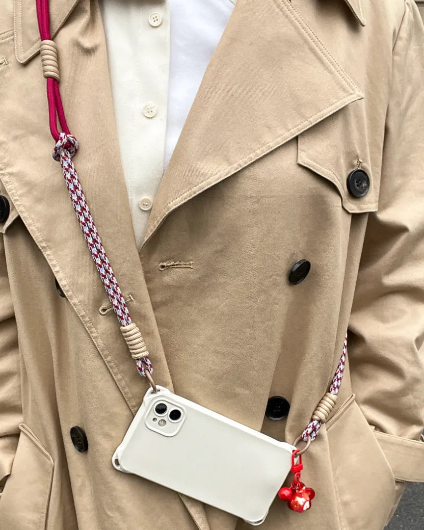 Phone strap styled with layered outfit, balancing fashion detail and practical hands free phone access#color_red