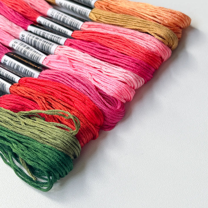 Colorful rainbow knitted fabric showing the result of using a mini weaving loom for creative mending and darning.