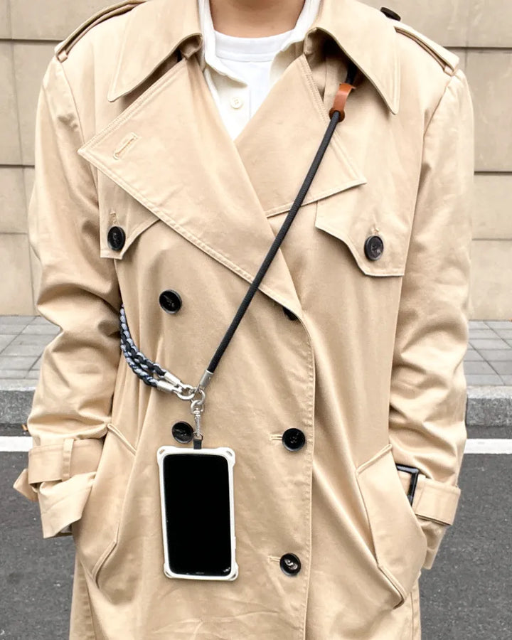 Rugged phone strap styled with trench coat outfit, combining functional design with practical everyday wear#color_black