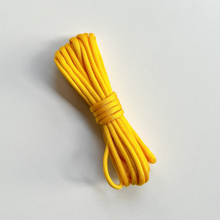 High-visibility yellow paracord braided nylon rope, heavy-duty strength for outdoor survival gear and DIY crafts.